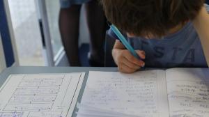 Child writing in a book.