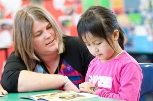 Child reading with teacher.